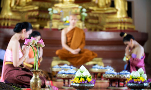 People wearing traditional clothing praying in temple