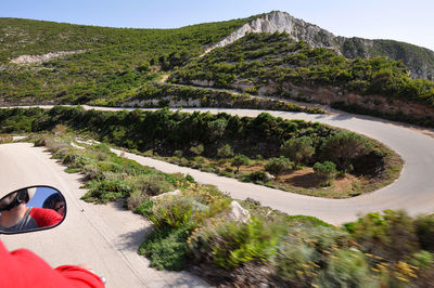 Scenic view of road by mountain against sky