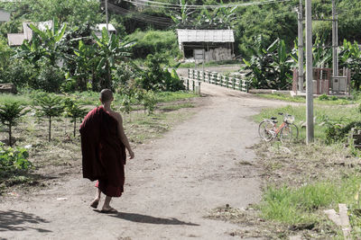 Rear view of woman walking by plants