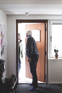 Doctor opening door for patient at home office