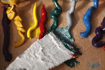High angle view of colorful paints on table at workshop
