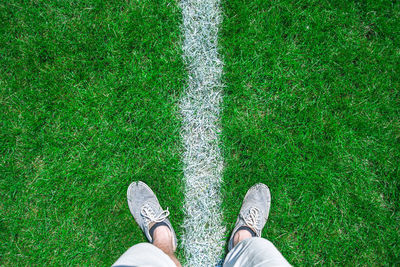 Low section of man standing on field