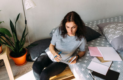 Portrait of young woman sitting on sofa at home