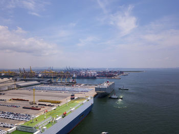 High angle view of city by sea against sky