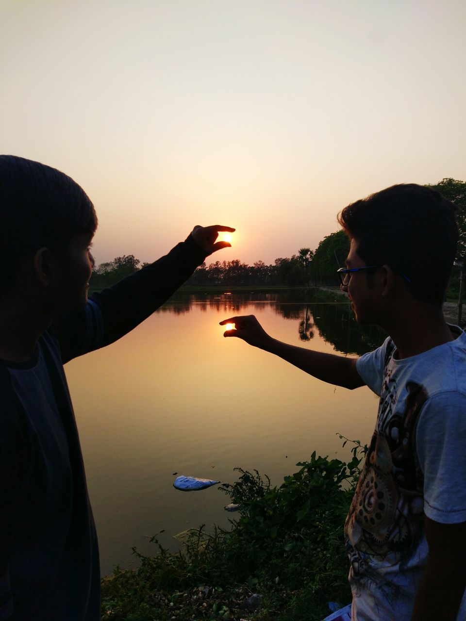 two people, sunset, togetherness, men, love, couple - relationship, young adult, heterosexual couple, lake, silhouette, friendship, happiness, lifestyles, adult, sky, water, women, people, human hand, outdoors, beauty in nature, nature, adults only, day