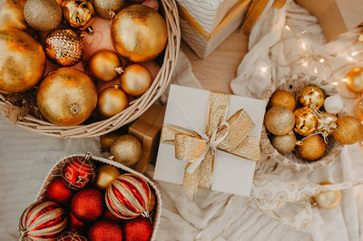 Huge wicker basket filled to the top with red and golden balls to decorate a christmas tree 