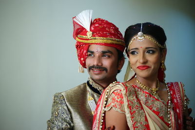 Smiling young couple standing against wall