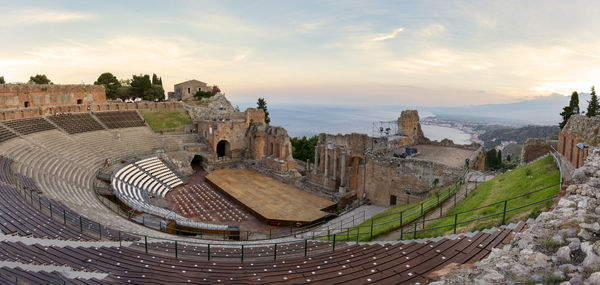 Ruins of ancient greek theater in taormina and etna volcano in the background. sicily panoramic view