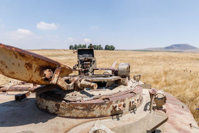 Old machinery on field against sky