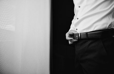 Midsection of businessman standing at home