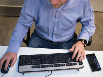 Midsection of man using mobile phone