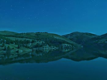 Scenic view of lake against blue sky at night