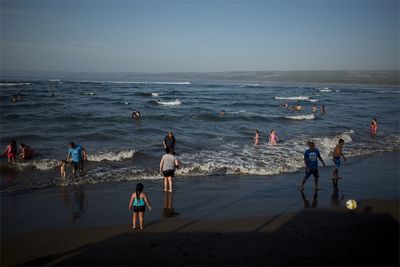 People on beach against sky