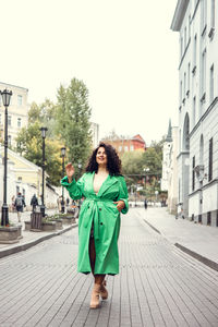 Portrait of woman standing on street in city