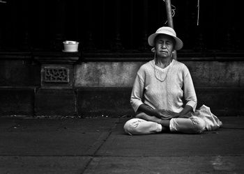 Portrait of man sitting on footpath