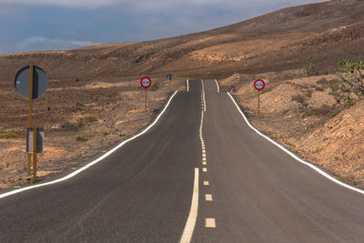 Road passing through city against sky