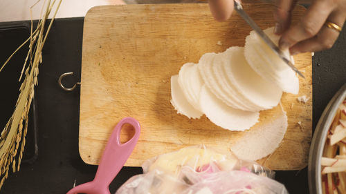 Midsection of person holding ice cream on table