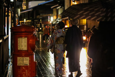 Rear view of men in city at night