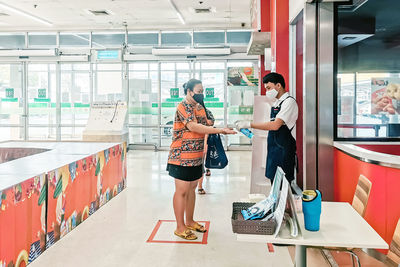 Side view of young couple standing against wall