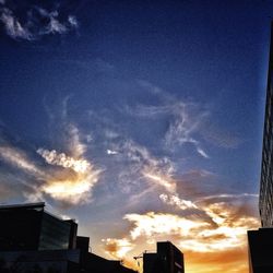 Low angle view of buildings against cloudy sky