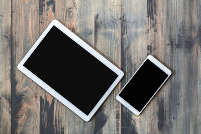 High angle view of smart phone on wooden table