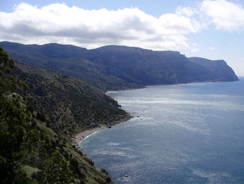 Scenic view of sea and mountains against sky