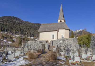 Church and cemetery in a village named st felix in south tyrol at winter time