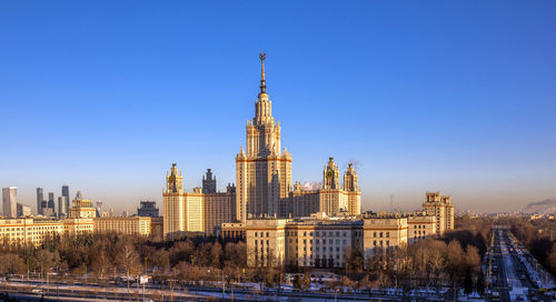 Front aerial view of morning autumn campus of moscow university with long shadows under blue sky