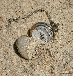 High angle view of clock on sand at beach