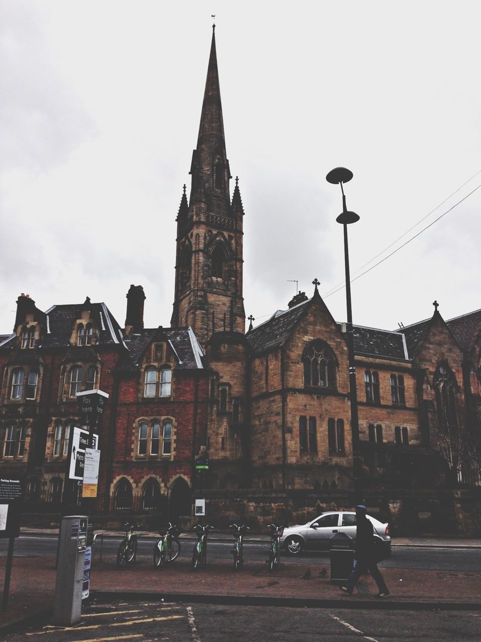 architecture, building exterior, built structure, transportation, sky, mode of transport, car, street, land vehicle, city, street light, low angle view, clear sky, building, outdoors, road, travel, facade, no people, history