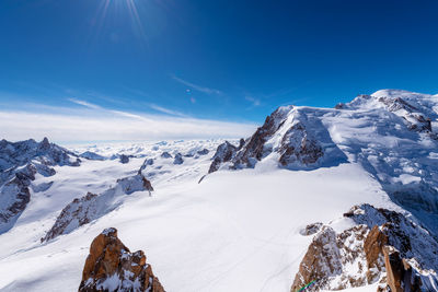 Snow covered mountains against blue sky