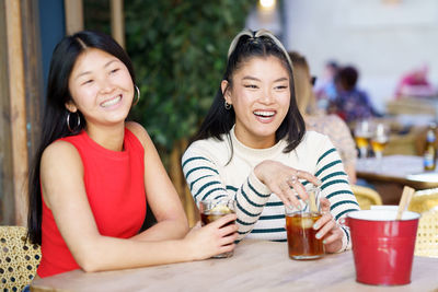 Portrait of smiling friends sitting at home