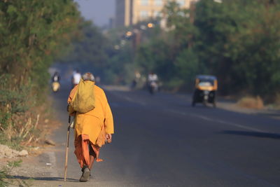 Rear view of man walking on road