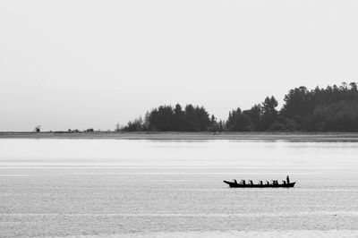 Boat sailing on sea against clear sky