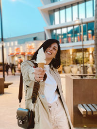 Portrait of smiling woman giving ice cream