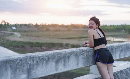 A young woman taking a breath of fresh air after exercising with a smiling face