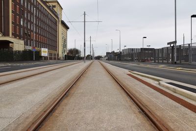 Surface level of railroad tracks by street against buildings in city