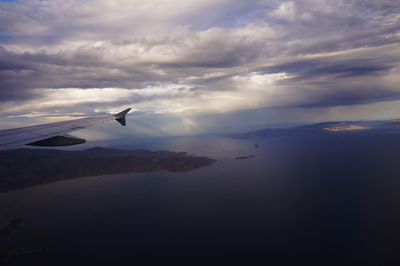 Airplane flying over sea against sky