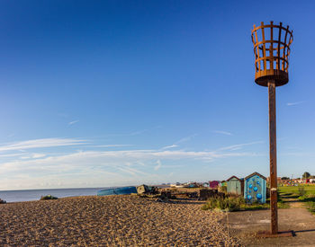 Lifeguard hut on beach against blue sky