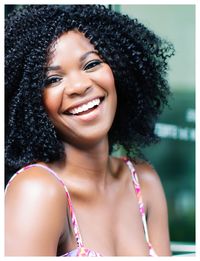 Close-up portrait of happy woman with curly hair