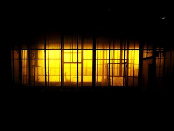 Illuminated building seen through window at night