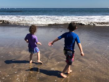 Rear view of boys on beach