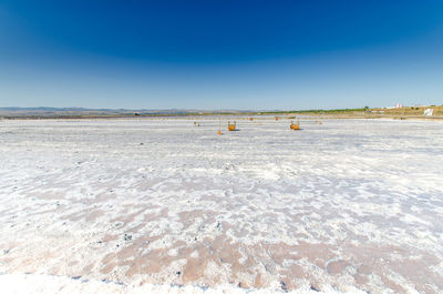 Scenic view of desert against clear blue sky