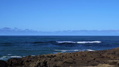 Scenic view of sea against clear blue sky