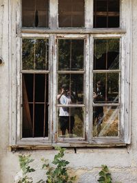 Man standing by window of building