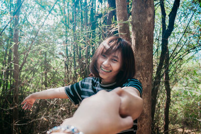 Portrait of smiling young woman in forest