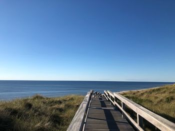 Scenic view of sea against clear blue sky