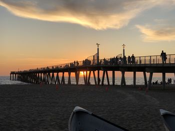 Pier over sea against sky during sunset