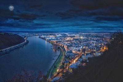 High angle view of river amidst buildings in city at night