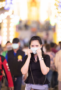 Asian female wear surgical mask while travel in night market new normal travel lifestyle in thailand